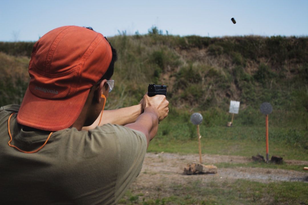 En mand skyder med pistol på en udendørs skydebane.